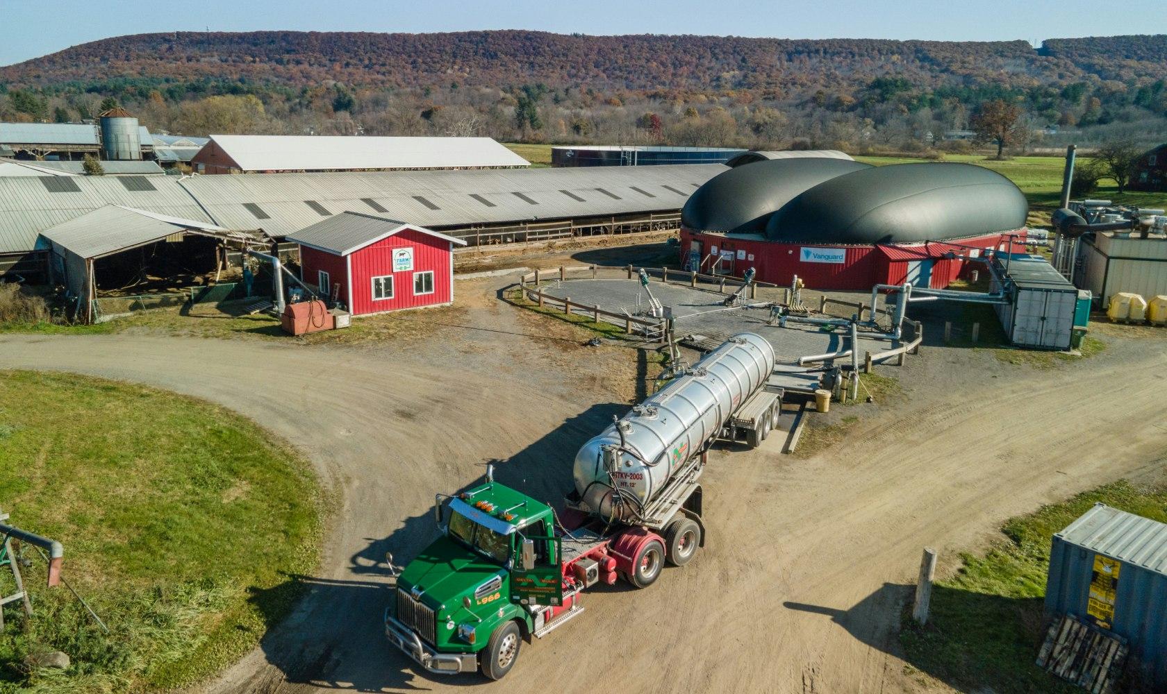 Truck hauling food and beverage waste to a farm powered anaerobic digester